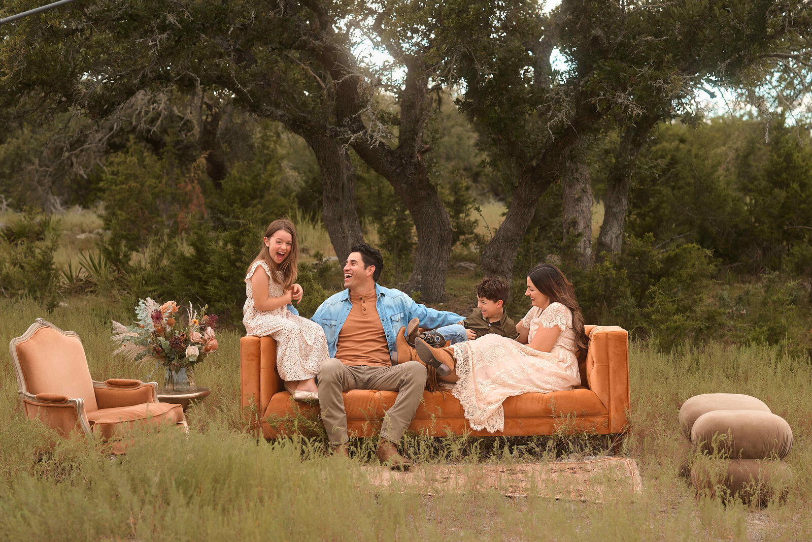 A family laughing together beneath a Texas oak tree